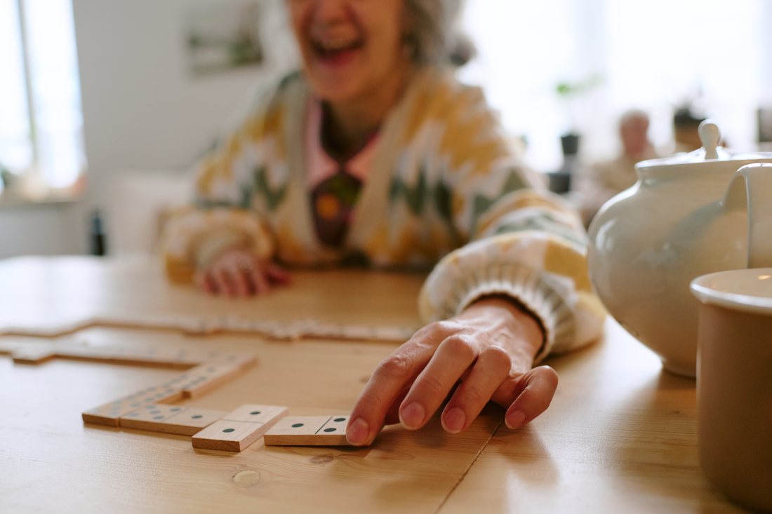 Seniorin bei einem Geschicklichkeits- und Gedächtnisspiel am Tisch