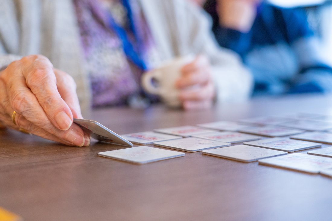 Hände legen Karten für ein Gedächtnisspiel auf den Tisch