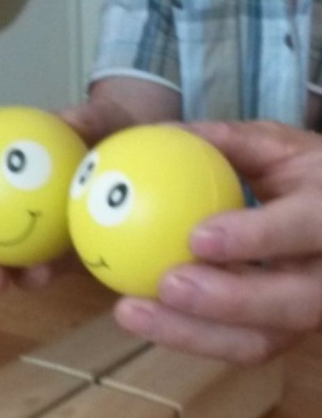 Zwei gelbe Bälle werden mit beiden Händen gehalten